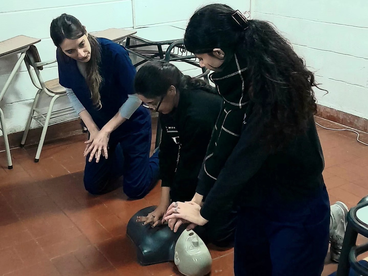 Profesionales enseñan maniobras de RCP sobre un maniquí